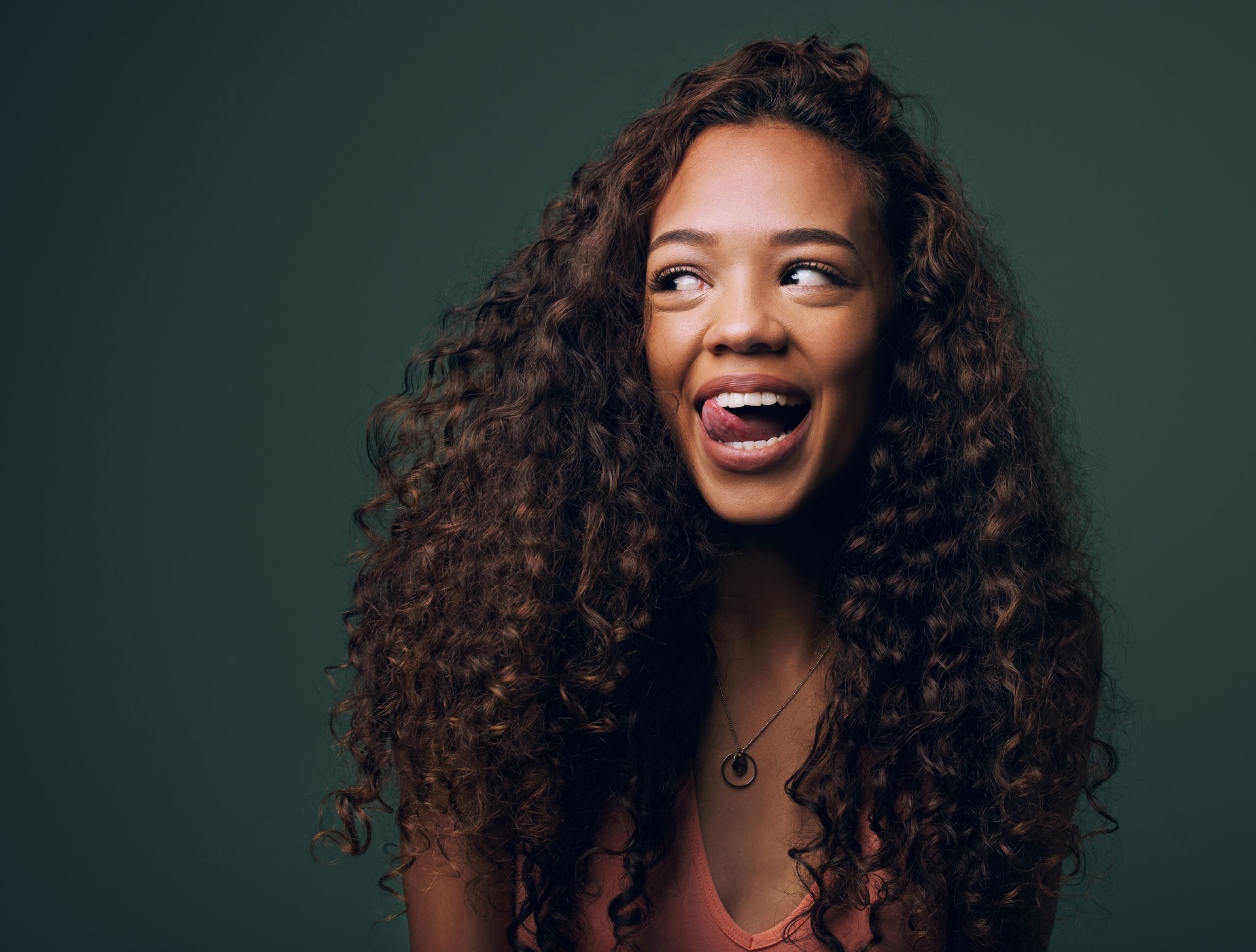 Cropped shot of an attractive and quirky young woman posing against a green background in studio